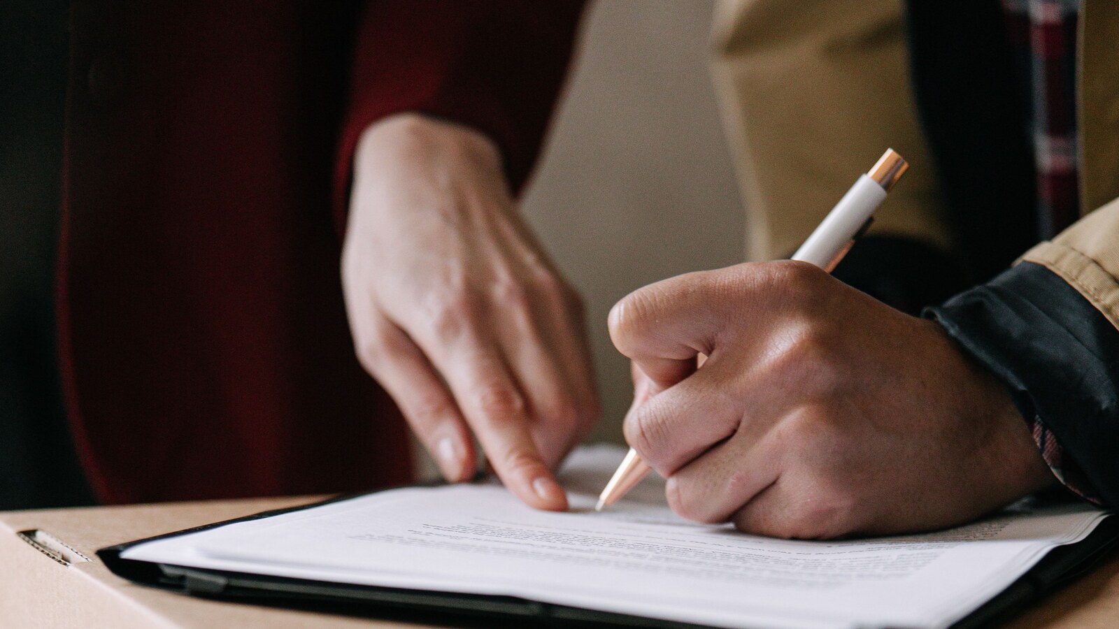 Signature d’un contrat de location sur des cartons de déménagement.